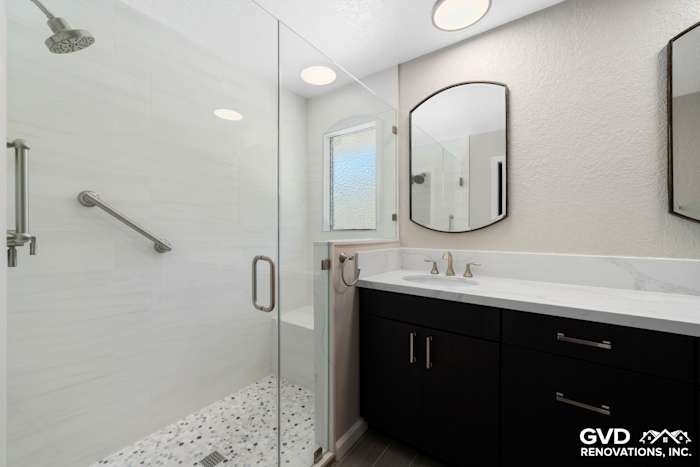 Modern master bathroom with walk-in shower, dark cabinetry, quartz countertop, and sleek fixtures in Rocklin, CA