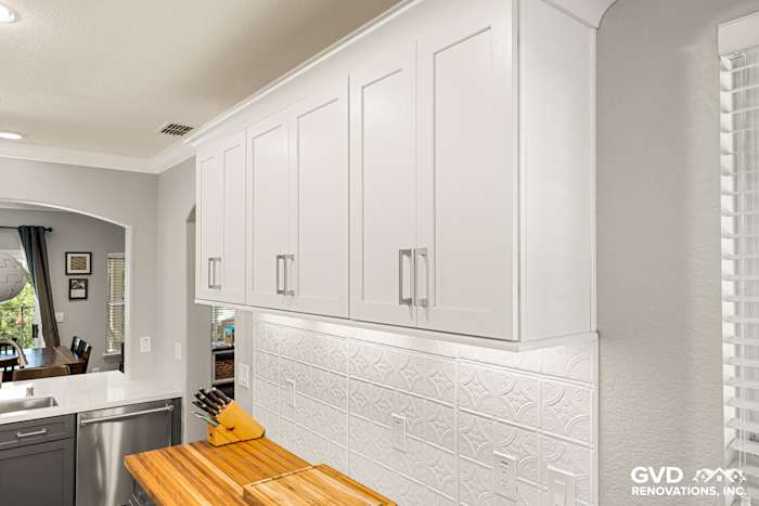Sleek white cabinetry and textured backsplash in modern Folsom kitchen remodel, featuring a wood countertop
