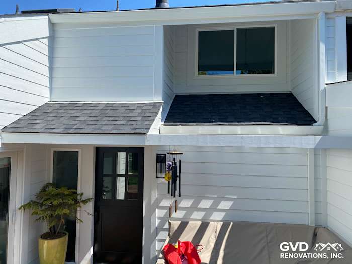 Bright white James Hardie lap siding on a Mill Valley home, featuring a black-shingled roof and modern porch design