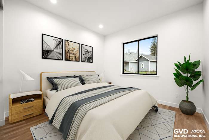 Cozy bedroom featuring a wooden bed frame, gray and white bedding, and large window with natural light