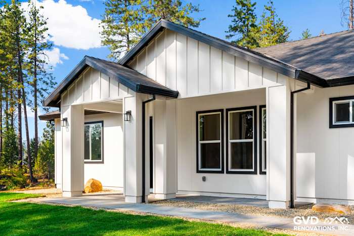 Modern new construction home exterior in Paradise, CA, featuring white board-and-batten siding and black accents