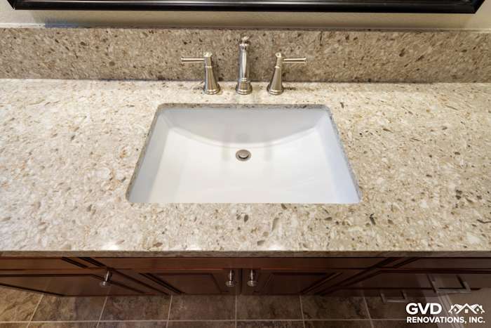 Modern bathroom sink with white porcelain basin, elegant granite countertop, and brushed nickel faucet