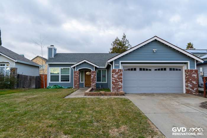 Home exterior featuring James Hardie Boothbay Blue siding, white trim, brick accents, and new Milgard windows in Sacramento