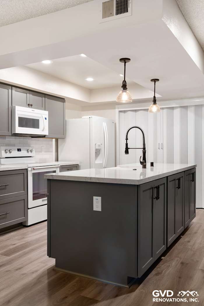 Modern kitchen remodel featuring gray cabinetry, white quartz island, and stylish pendant lighting in Sacramento