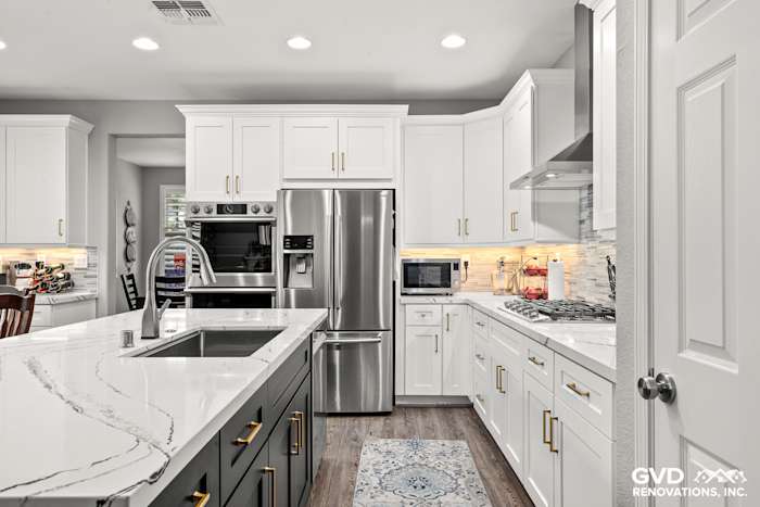 Modern kitchen remodel in Roseville with white cabinets, Cambria countertops, stainless steel appliances, and wood flooring