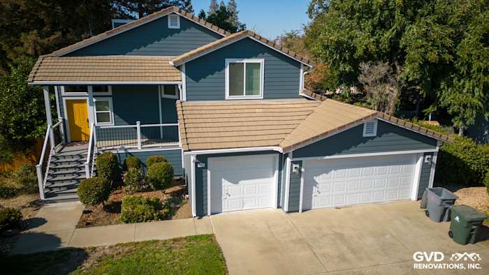 Updated home exterior in Dixon, showcasing new blue siding, Anlin windows, and a refreshed deck with side steps