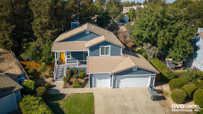 Newly updated home exterior in Dixon, featuring blue siding, new Anlin windows, and a refreshed deck