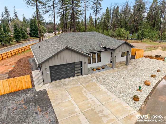 New construction home exterior featuring James Hardie Architectural Panels, black Milgard windows, and a gravel landscape