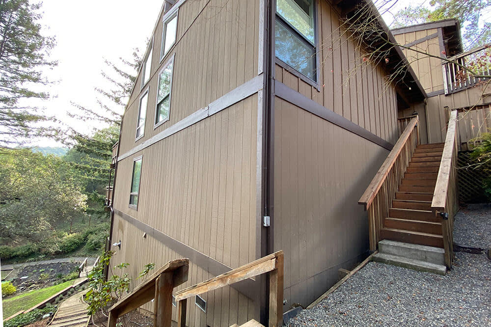 Wooden siding and steps leading to home, surrounded by greenery in Novato, California