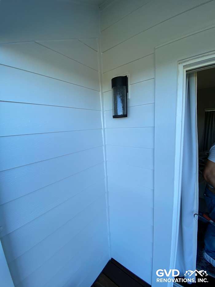 New pre-finished James Hardie lap siding on home corner with modern light fixture in Mill Valley, CA