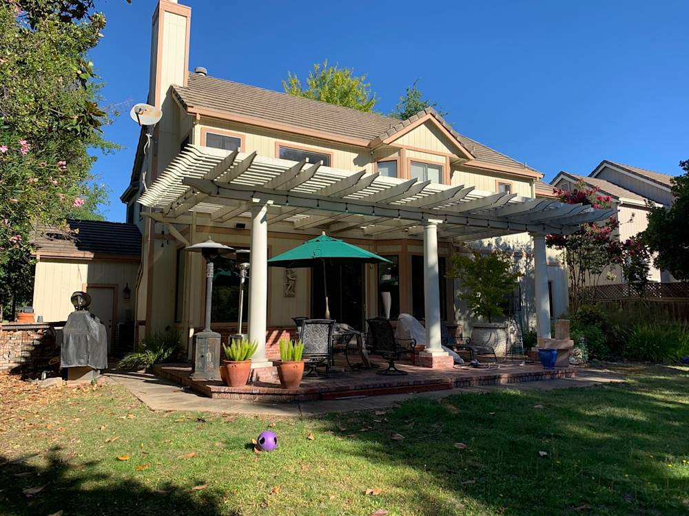Overgrown yard with patio, pergola, and grill, typical Sacramento home features