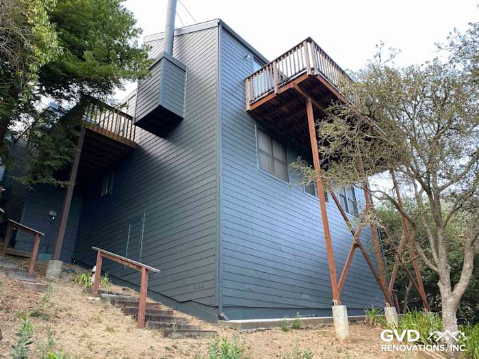 New dark blue James Hardie siding installed on a modern Mill Valley home with a wooden balcony