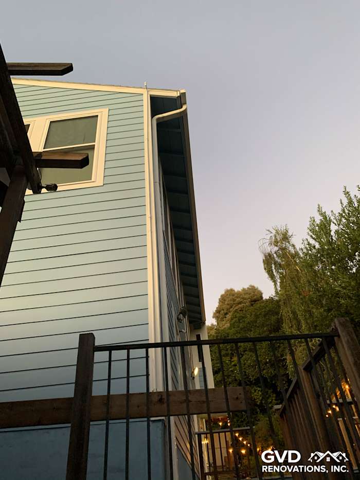 Custom Colonial Smooth Lap James Hardie siding in light blue with new vinyl windows on home exterior in Oakland