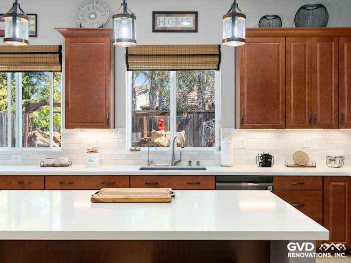Modern kitchen in Elk Grove featuring brown cabinetry, white countertops, and natural light from large windows