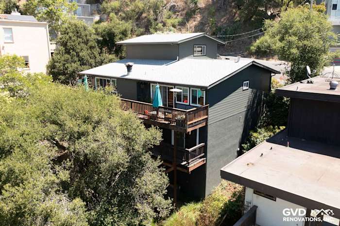 Oakland home featuring Iron Gray James Hardie lap siding and a multi-level deck among trees