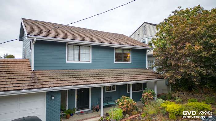 Two-story home exterior featuring Evening Blue Cedarmill HardiePlank siding and Rustic Grain Arctic White trim in Oakland
