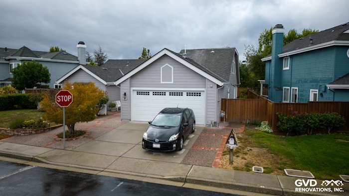 Home exterior featuring new James Hardie Pearl Gray siding, Milgard windows, and landscaped yard in Foster City