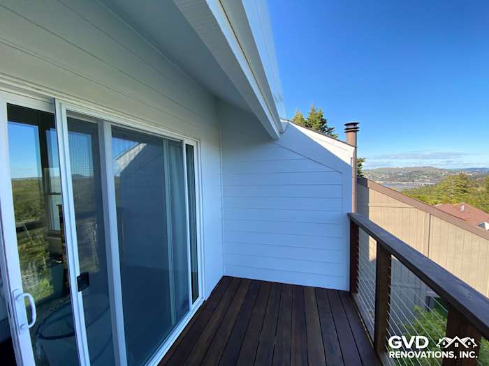 New James Hardie lap siding on a bright porch with wooden railing and stunning hillside views in Mill Valley
