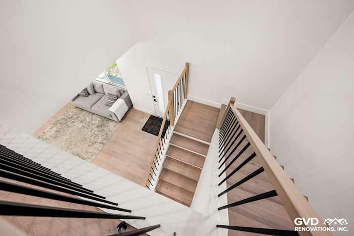 Bright, open staircase with wooden railings and new flooring, seen from above in Antelope home remodel