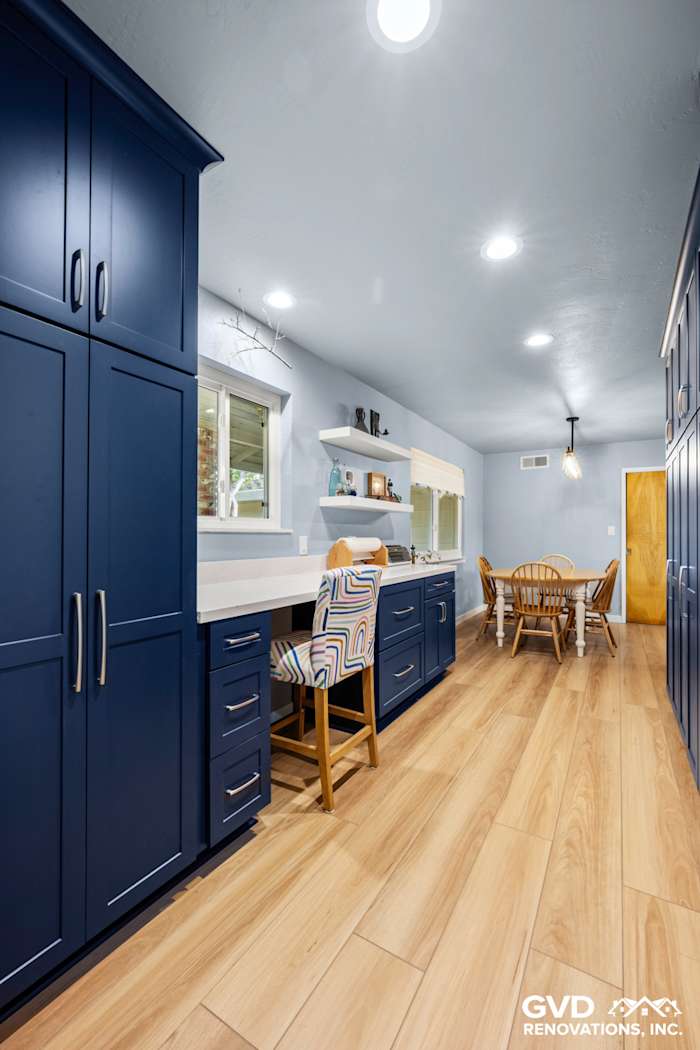 Modern kitchen remodel featuring navy blue cabinets, light wood flooring, and a cozy dining area in Fair Oaks, CA