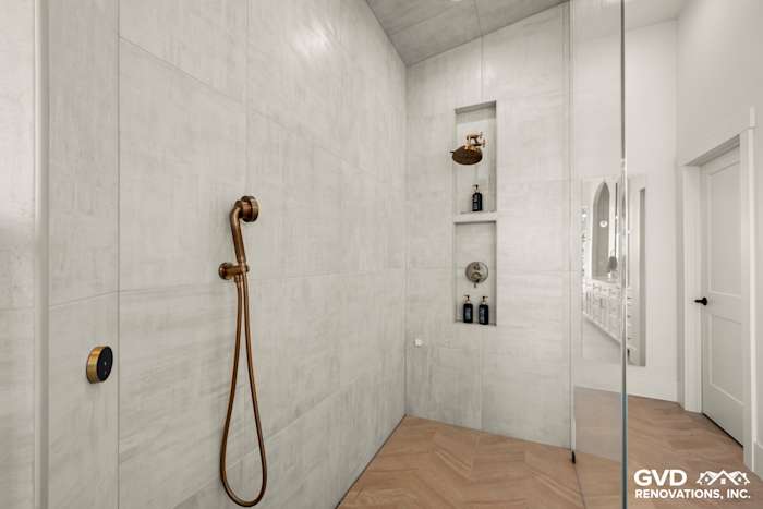 Luxurious zero-threshold steam shower with custom tile, bronze fixtures, and niche shelving in El Dorado Hills bathroom