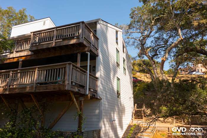 New Arctic White James Hardie siding installed on a two-story home exterior with wooden balconies in Novato, CA