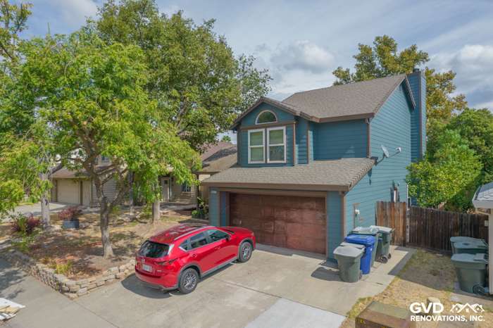 Home exterior featuring primed and painted James Hardie siding in blue, Anlin Windows, and a red SUV in Antelope, CA