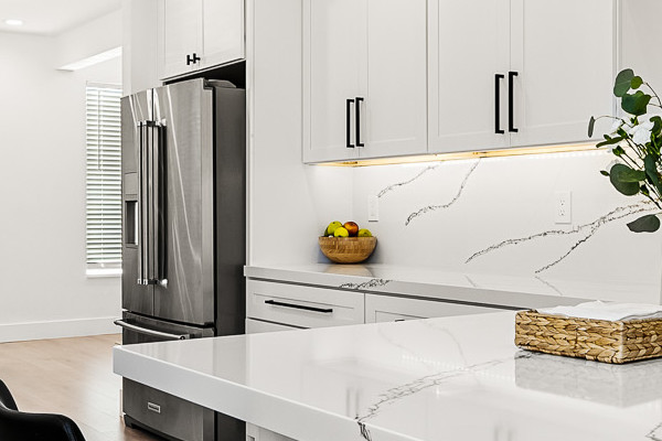 Modern Antelope kitchen featuring white quartz countertops, custom cabinets, and sleek black bar stools