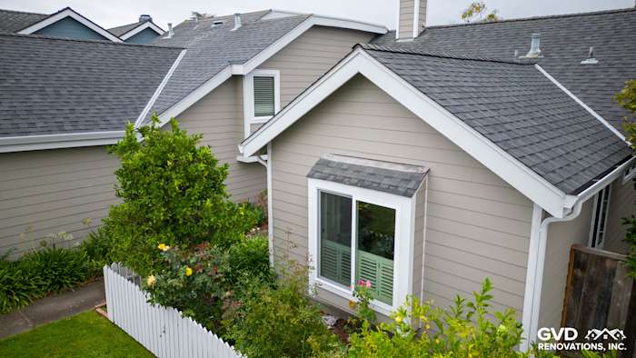 Monterey Taupe James Hardie siding with Arctic White trim and new Milgard windows, surrounded by landscaping in Foster City