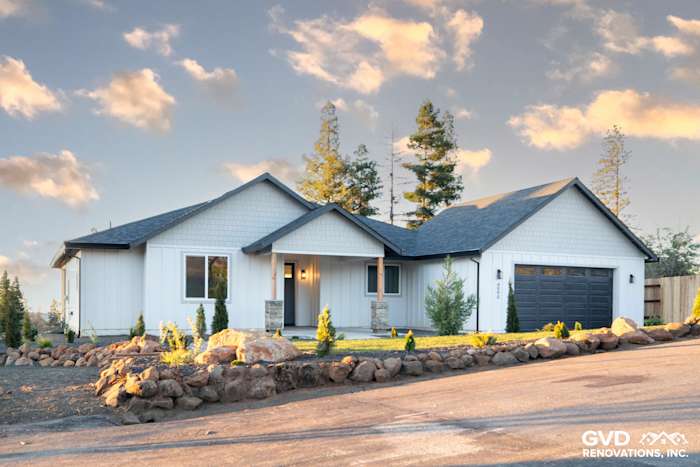 Single-story new construction home with James Hardie Board and Batten siding, stone accents, and a modern garage door