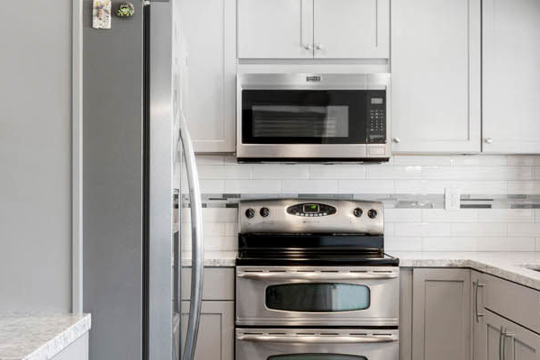 Modern kitchen remodel in Carmichael featuring gray cabinets, quartz countertops, and pendant lighting