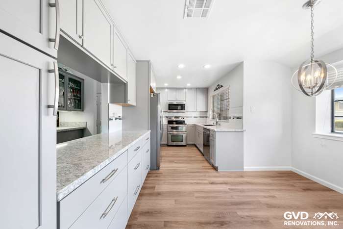 Modern kitchen remodel in Carmichael featuring gray cabinets, quartz countertops, and pendant lighting