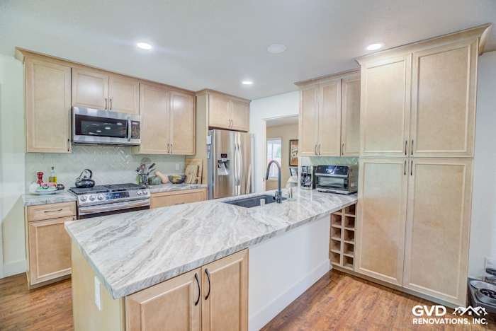 Modern kitchen remodel featuring light wood cabinets, quartz countertops, stainless steel appliances, and a kitchen island
