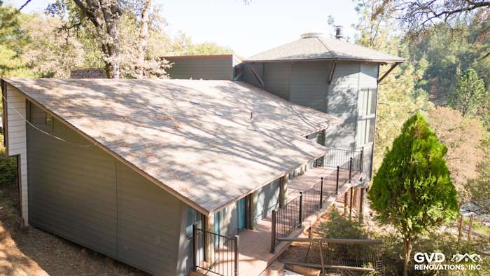 Exterior of Meadow Vista home featuring Iron Gray HardiePlank siding and a spacious deck surrounded by trees