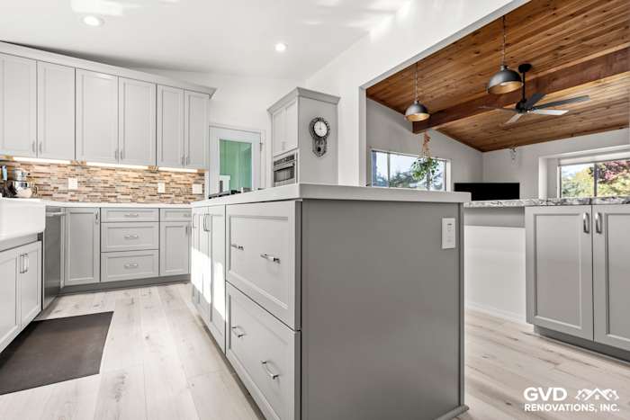 Modern kitchen remodel with light gray cabinets, quartz countertops, and a wood-paneled ceiling in Greenwood, CA