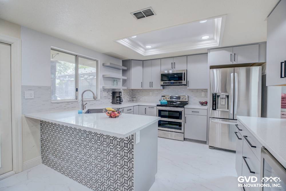 Modern kitchen remodel with gray cabinetry, white quartz countertops, and patterned backsplash in Sacramento