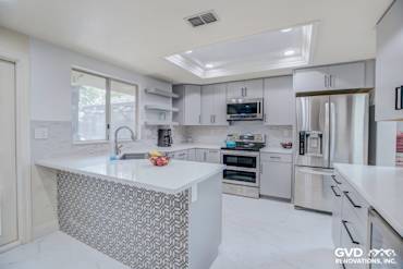 Modern kitchen remodel with gray cabinetry, white quartz countertops, and patterned backsplash in Sacramento