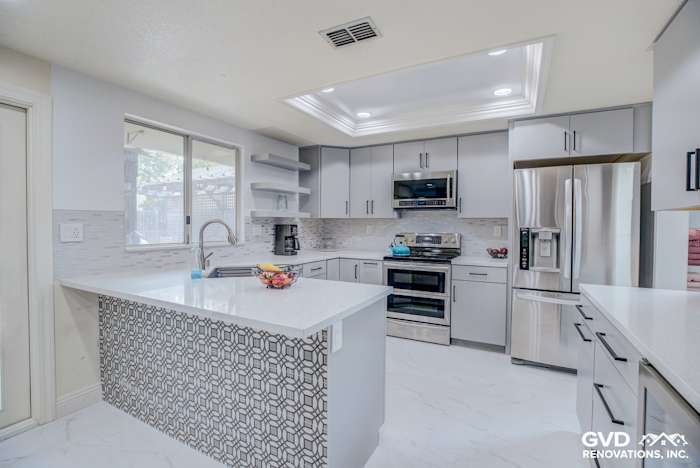 Modern kitchen remodel with gray cabinetry, white quartz countertops, and patterned backsplash in Sacramento