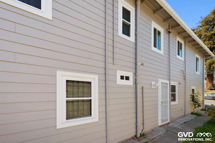 Pearl Gray James Hardie siding with Arctic White trim and Alside Mezzo windows in Oakland exterior renovation