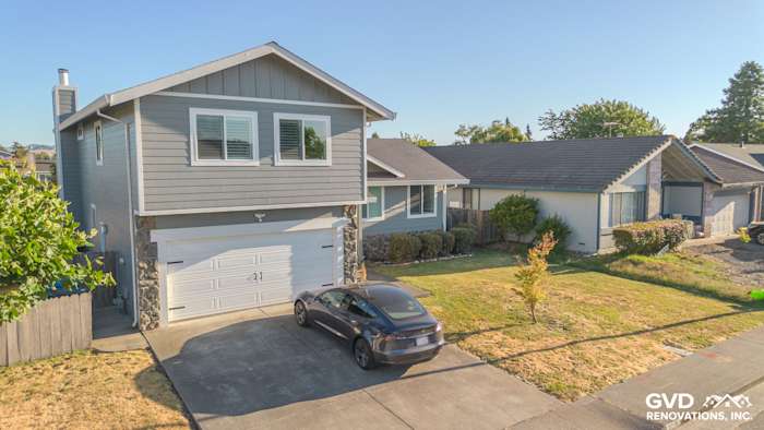 Modern two-story home in Petaluma with gray James Hardie siding and white trim, featuring a landscaped yard and driveway