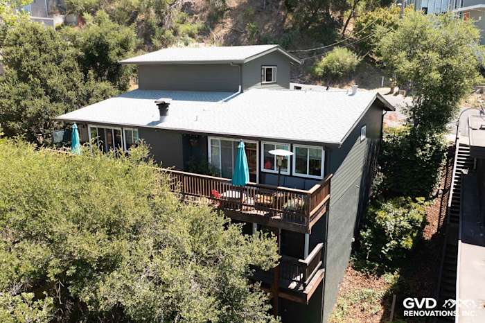 Oakland home exterior featuring Iron Gray James Hardie siding and a wooden deck surrounded by greenery