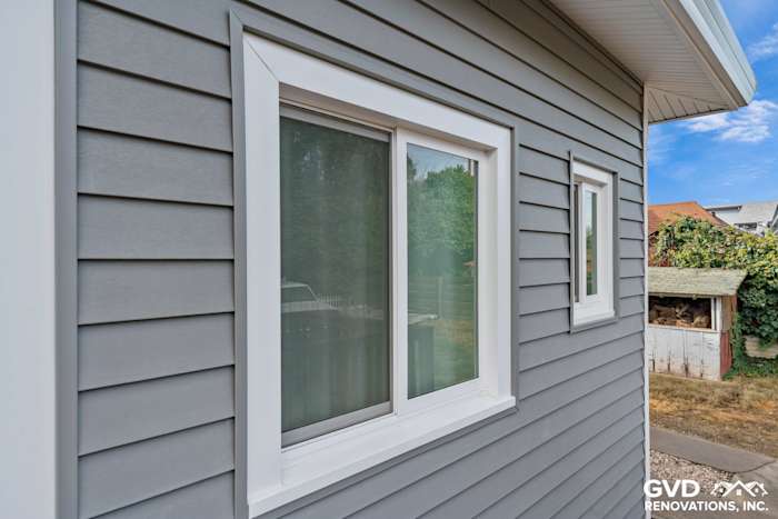 Freshly installed light gray vinyl siding with white trim around new windows in Dixon, CA home