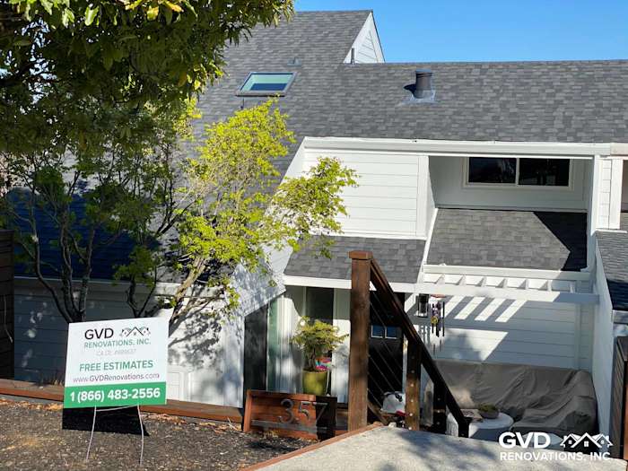 Newly installed James Hardie lap siding, gray shingles, and wooden deck railing on a home in Mill Valley