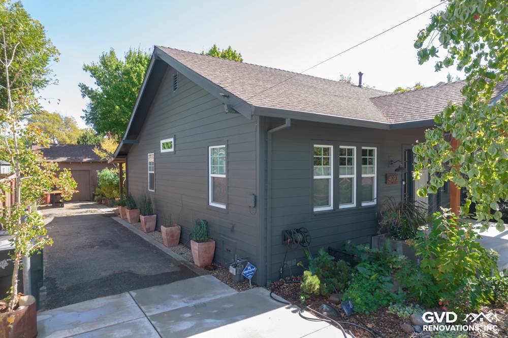 Updated dark gray siding with new landscaping and fresh concrete path in Sacramento