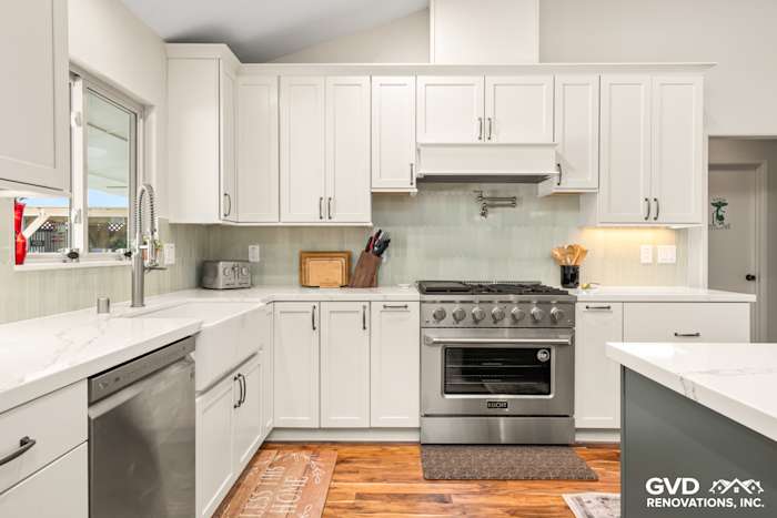 Bright modern kitchen with white cabinets, quartz countertops, and a stainless steel stove in Carmichael, CA
