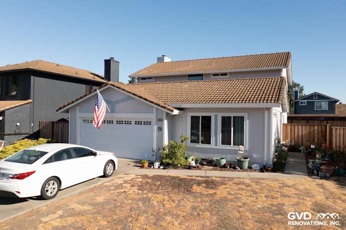 Updated home exterior with new white siding, black windows, and potted plants, showcasing enhanced curb appeal in Petaluma