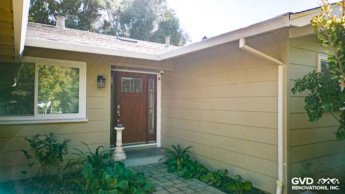 Welcoming entryway featuring James Hardie Lap Siding in soft beige with a wooden door and landscaping