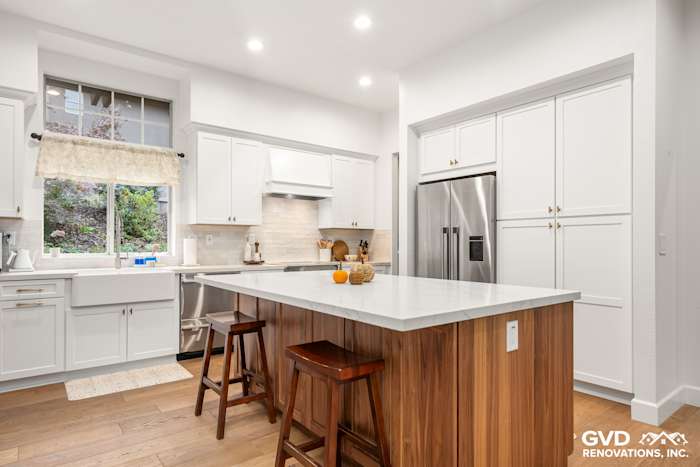 Modern Folsom kitchen with Waypoint cabinets, Vadara Bronzo countertops, wood island, and bright lighting