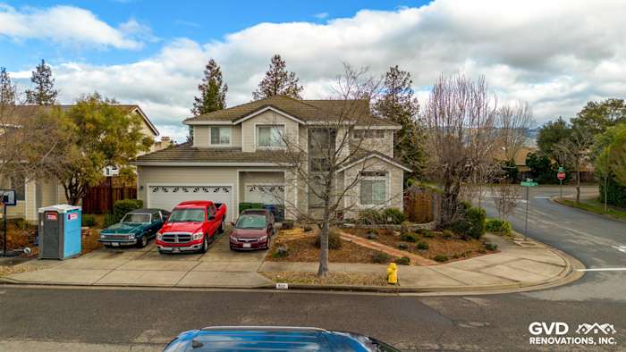 Petaluma home featuring James Hardie Cobble Stone siding with Arctic White trim, landscaped yard, and driveway with parked