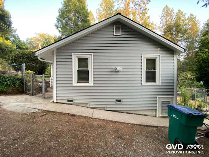 Home exterior featuring Prodigy Vinyl Siding in light gray, showcasing a clean transformation in Grass Valley